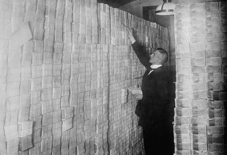 یک بانکدار برلینی پشته‌های مارک های بسته بندی شده را می شمارد.